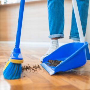 person sweeping the floor with a broom