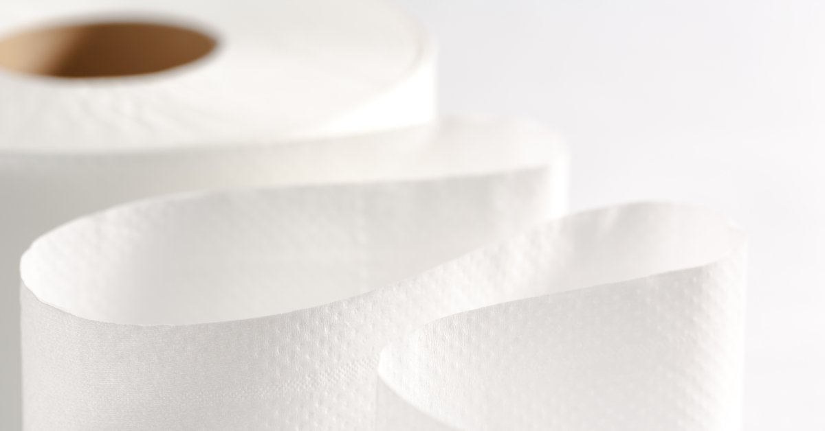 A close-up of a single roll of toilet paper. Some of the tissue is unraveled from the roll and the texture is visible.
