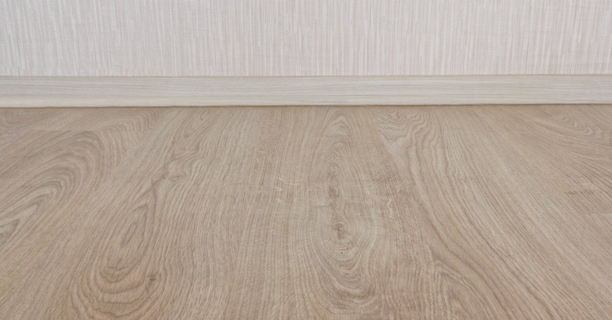 A sample of laminate plinth wall paneling, showcasing a smooth finish with a light wood grain texture.