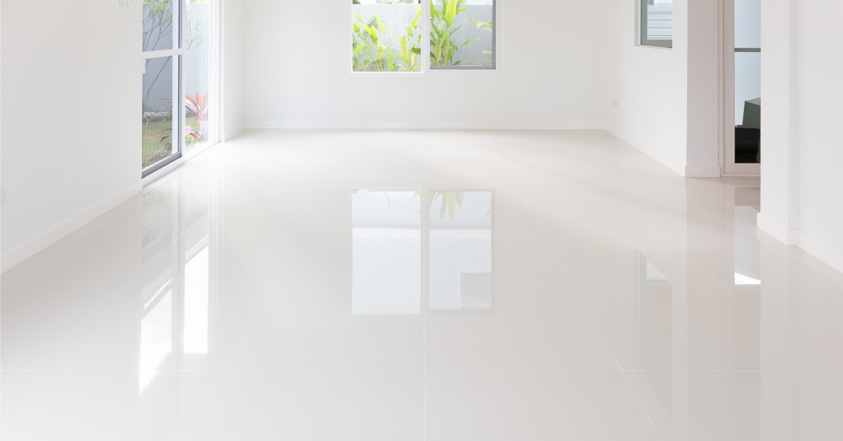 A white glossy ceramic tile floor displaying a sleek and reflective surface that highlights the uniformity and shine.