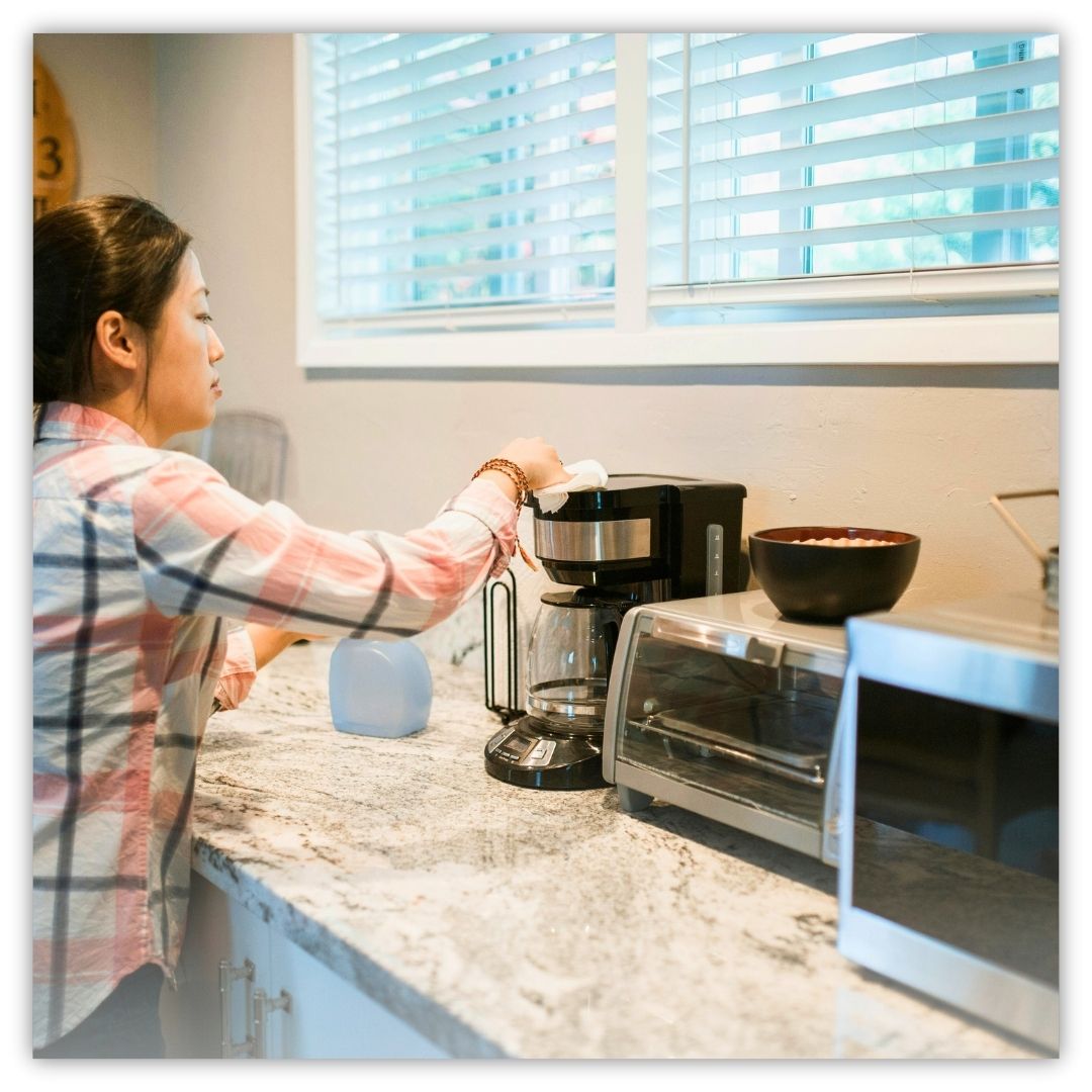 a woman cleaning a coffee maker